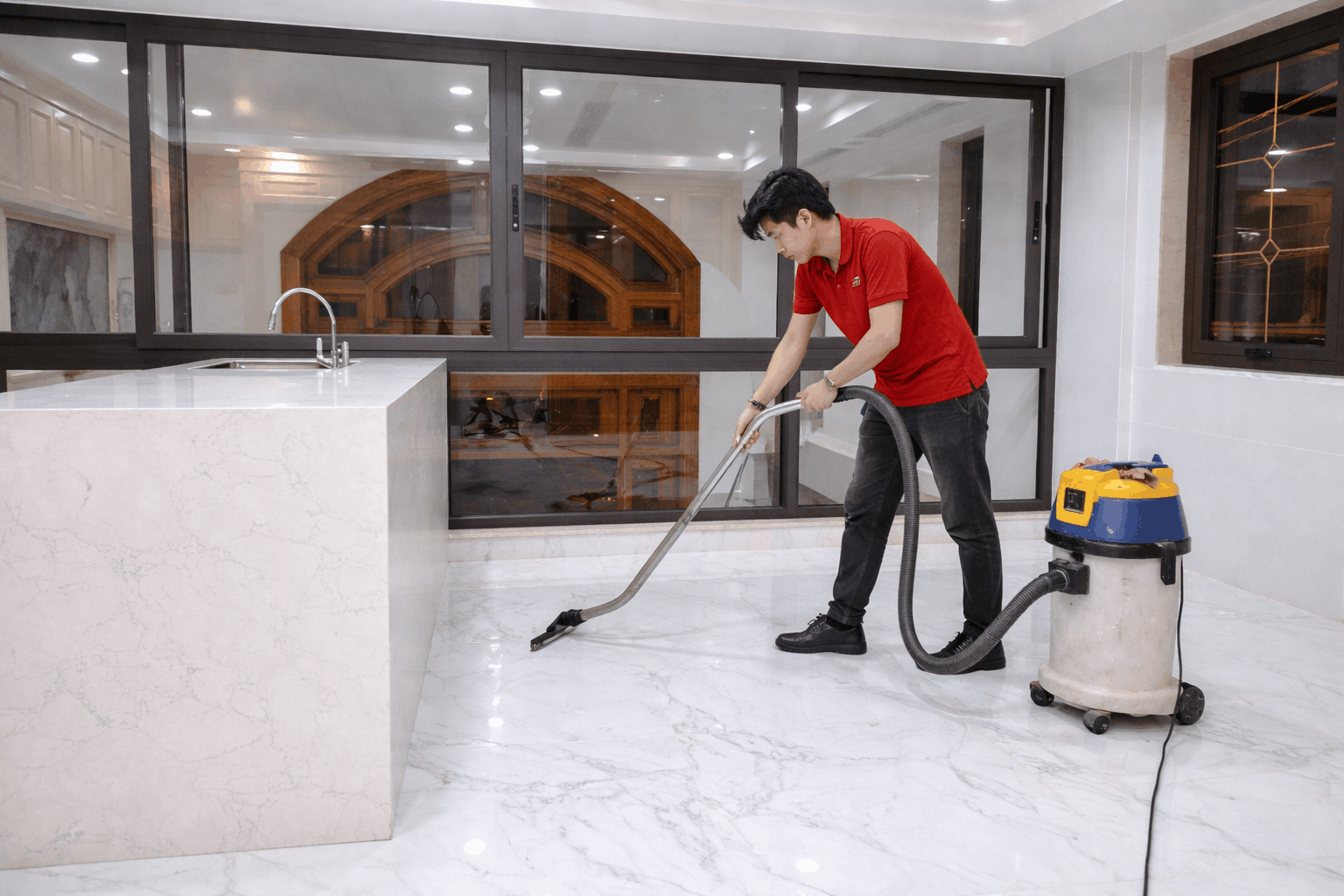 Nhân viên vệ sinh sau xây dựng MCX Clean đang hút bụi sàn nhà bằng máy công nghiệp