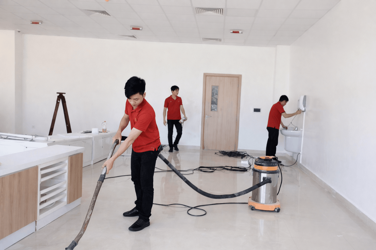 Nhân viên vệ sinh sau xây dựng MCX Clean đang hút bụi và làm sạch văn phòng